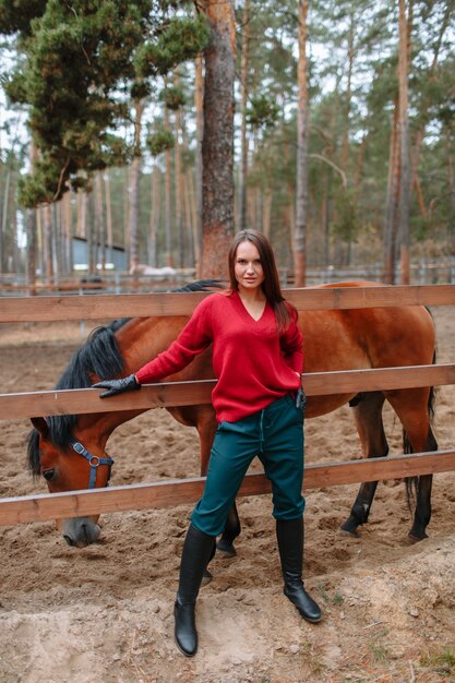 Una niña de pie junto a un caballo.