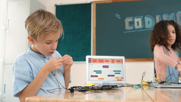 Niña de pie mientras arregla una placa electrónica usando la pedagogía del destornillador