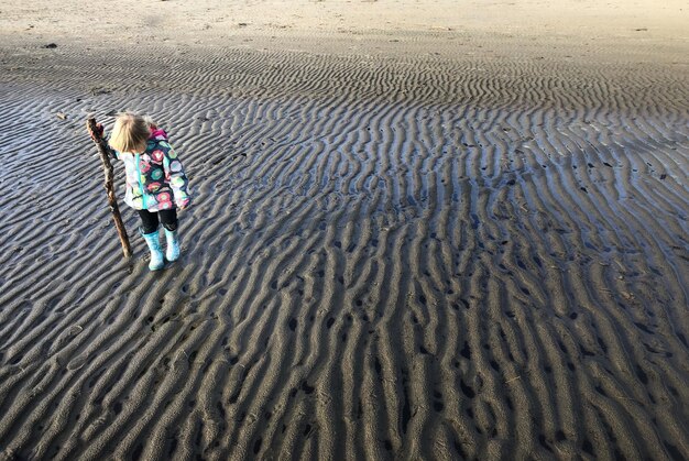 Foto niña de pie en la playa