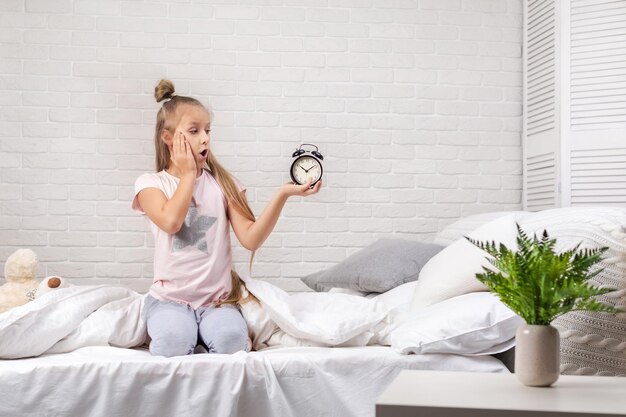 Foto niña en pijama con reloj