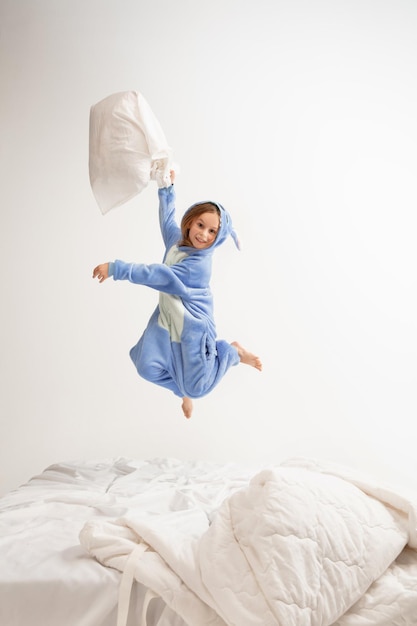 Niña en pijama suave y cálido con fiesta de colores brillantes jugando en casa