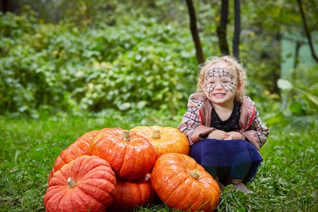 Foto una niña con una pila de calabazas.