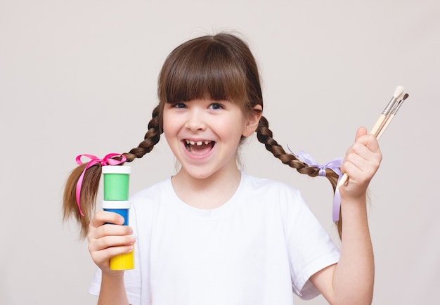 Niña con pincel y pinturas