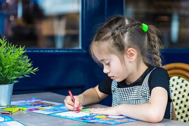 Niña pinta con lápices de colores