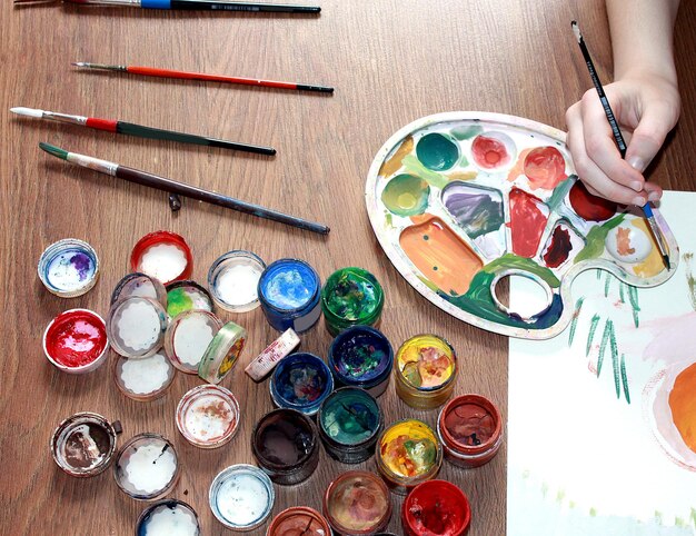 Una niña pinta con pintura Primer plano de una mano