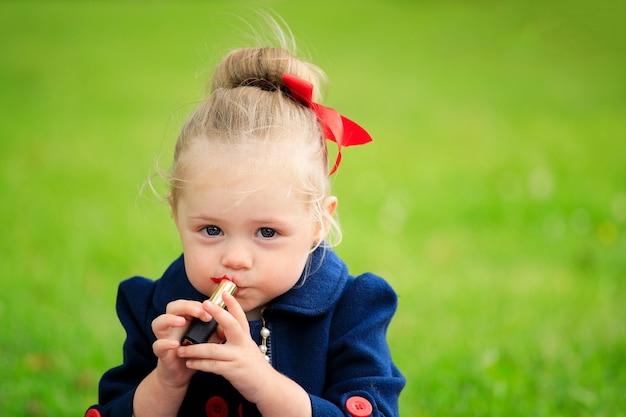 Niña pinta sus labios con lápiz labial