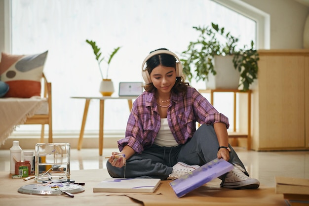 Niña pintando cuadros en el dormitorio