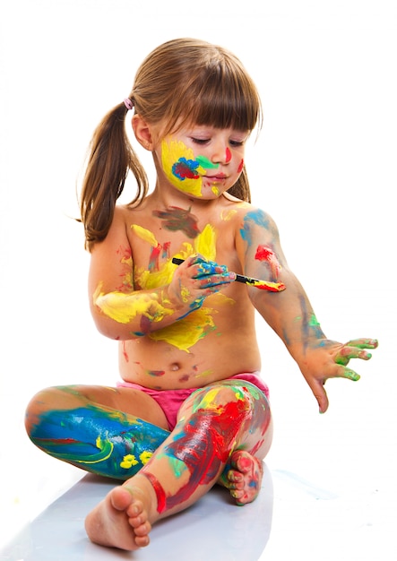 Foto niña pintando con pincel y pinturas de colores