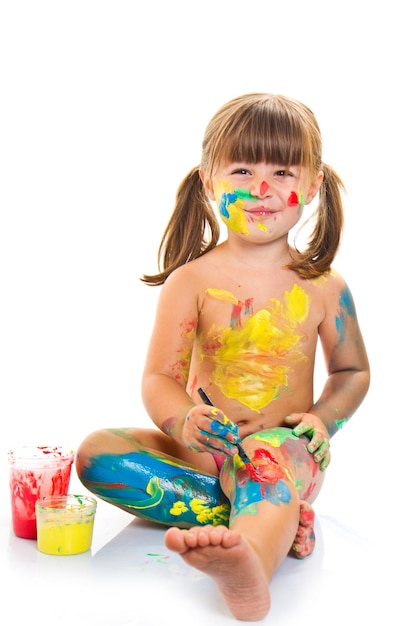 niña pintando con pincel y pinturas de colores