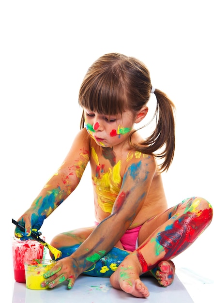 niña pintando con pincel y pinturas de colores