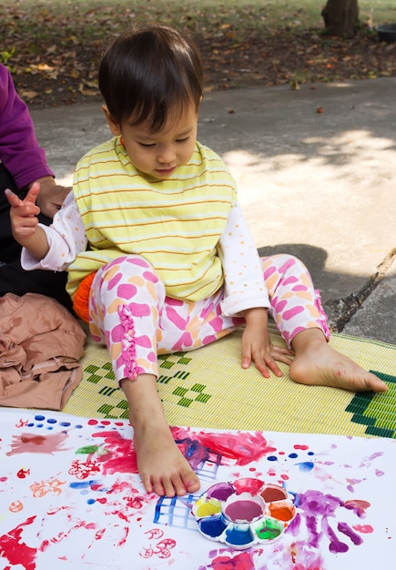 Foto niña pintando sobre papel blanco