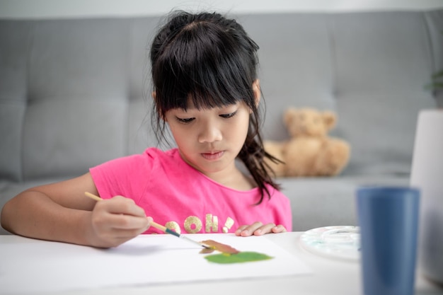 Niña pintandoNiña pintando Cuadro en la mesa en casa Cuadro en la mesa en casa