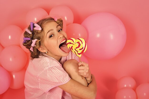 Niña con piruleta de caramelo.