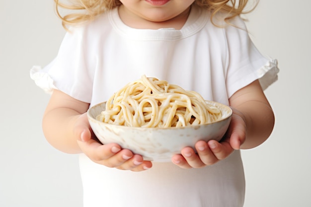 Una niña con un plato de fideos