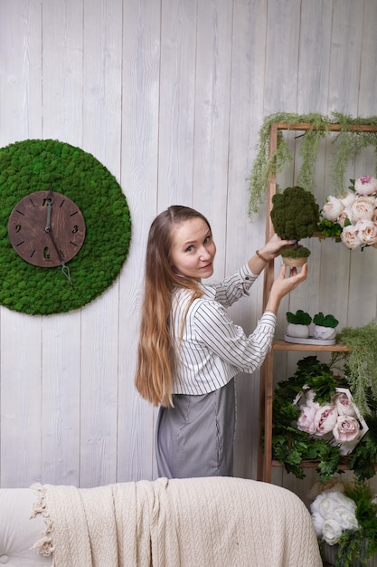 La niña pone flores en el estante.