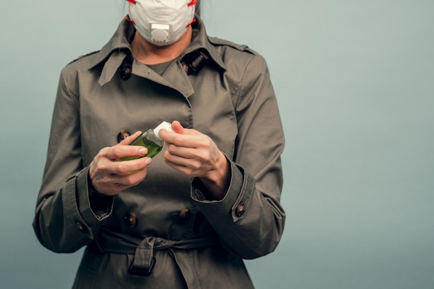 Foto una niña se pone una máscara protectora. uso de un gel antiséptico. protección respiratoria del coronavirus. equipo de protección personal para una pandemia de infección viral. covid-19.