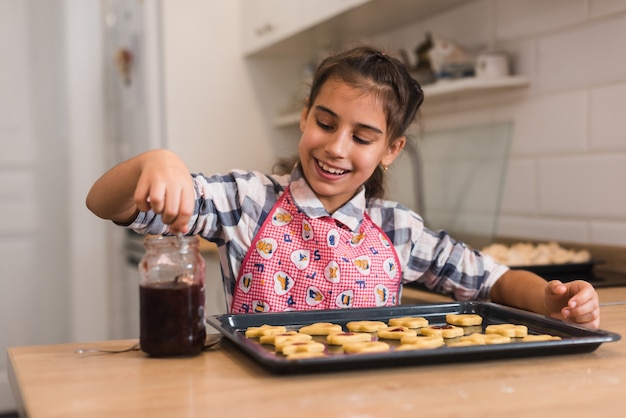 Niña Poniendo Mermelada De Galletas En Una Bandeja.