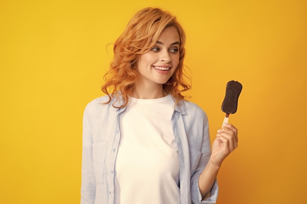 Niña posando con helado de chocolate en un fondo amarillo aislado mujer de verano