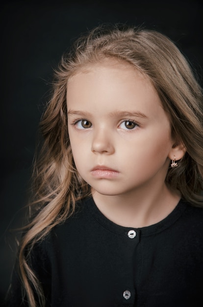 Niña posando perfectamente en el estudio sobre un fondo negro