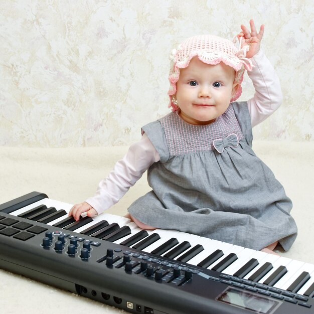 Niña posando con piano electrónico