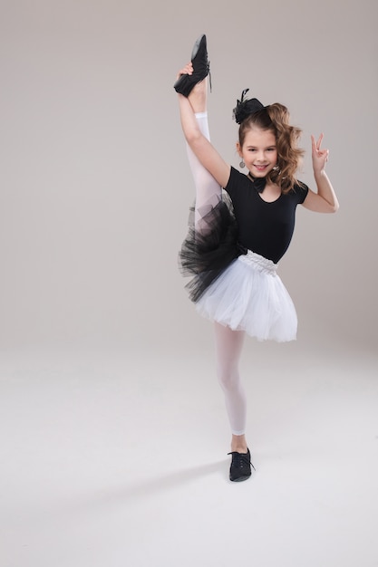 Niña posando con su pierna en traje de baile.