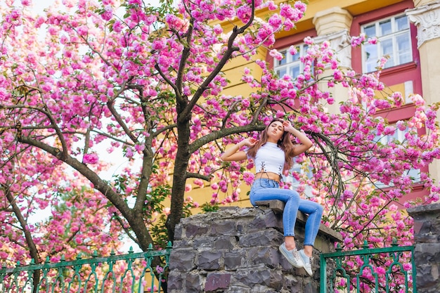 Foto niña, posar, con, rama, flores, exterior