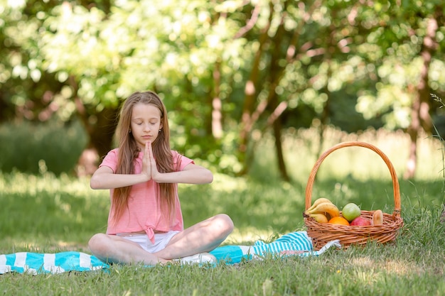 Niña en posición de yoga en el parque