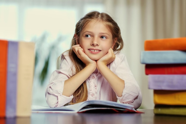 A una niña positiva le gusta leer muchos libros.