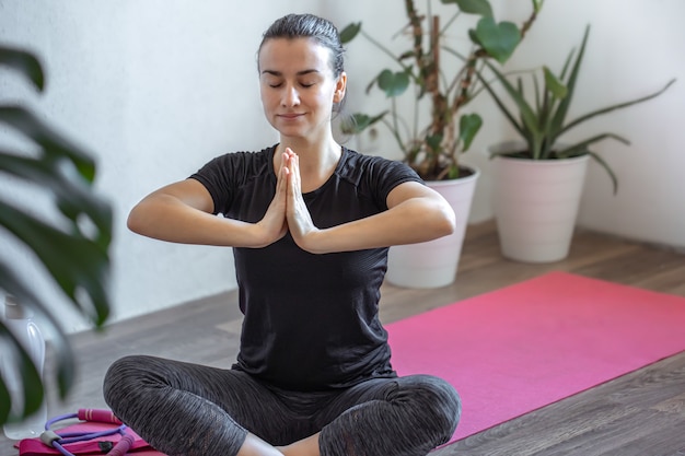 Niña practica yoga en casa en la estera