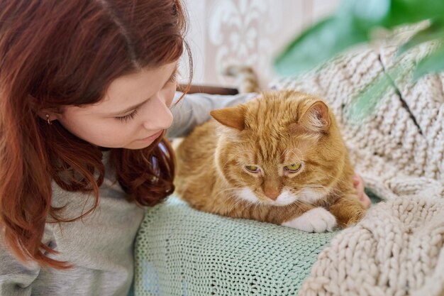 Niña preadolescente abrazando gato con cara de amor de cerca Casa mascota viejo gato jengibre con joven dueño juntos Animales amor amistad niños estilo de vida concepto