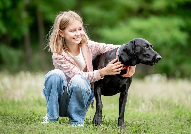 Niña preadolescente abrazando a un perro golden retriever sentado en la naturaleza juntos niño lindo acariciando a un perro de pura raza