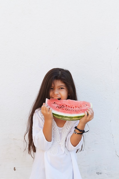 Niña preadolescente comiendo sandía. Infancia feliz. Chica de verano.