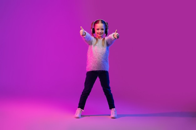 Niña preadolescente experimenta una nueva forma de aprendizaje interactivo usando auriculares