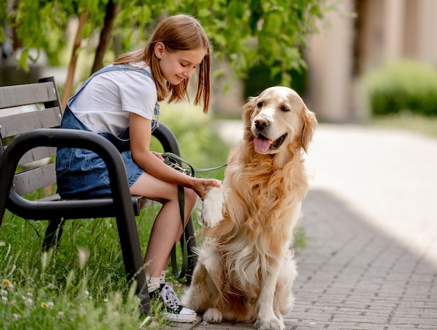 Niña preadolescente con perro golden retriever