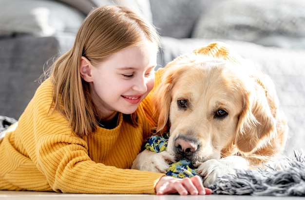 Niña preadolescente con perro golden retriever