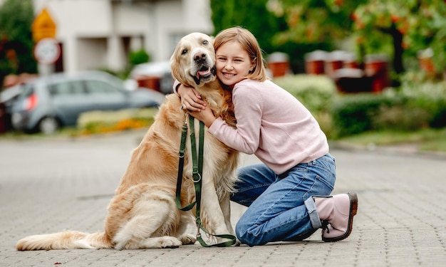 Niña preadolescente con perro golden retriever