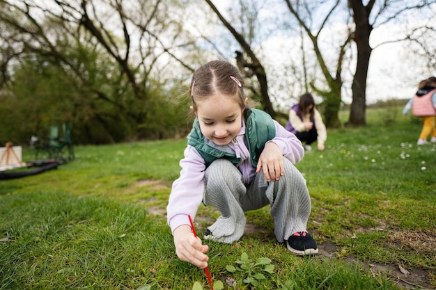 Niña preescolar dibuja una hierba verde con un cepillo