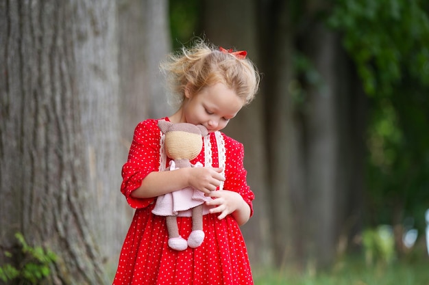 una niña preescolar rubia en una corona de serbal y con juguetes