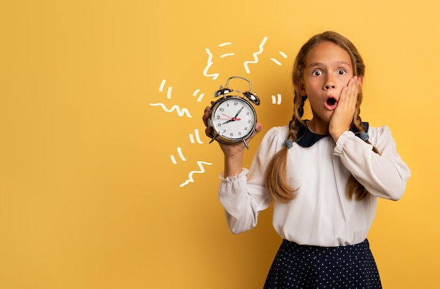 Niña preocupada por la alarma del reloj que recuerda un evento