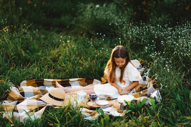 Una niña se prepara para un picnic en el jardín.
