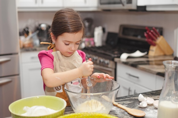 Niña preparando comida en casa
