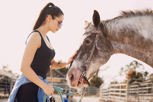 Niña preparándose para montar a caballo