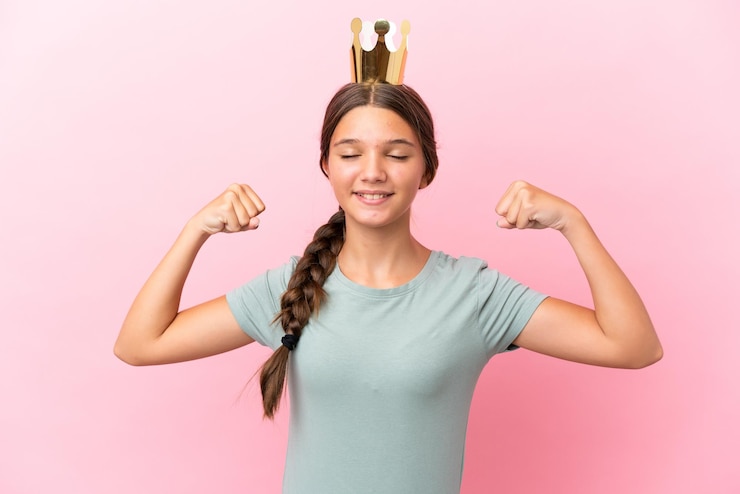 Foto niña princesa caucásica aislada de fondo rosa haciendo un gesto fuerte