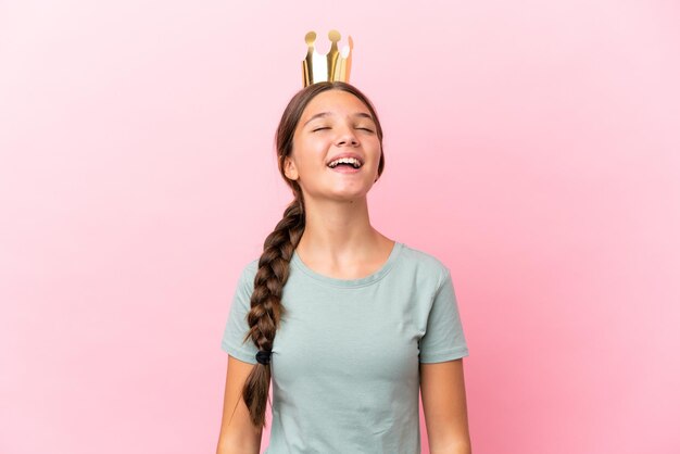 Niña princesa caucásica aislada sobre fondo rosa riendo