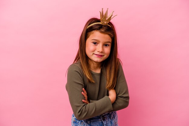 Niña princesa con corona aislada en rosa riendo y divirtiéndose.