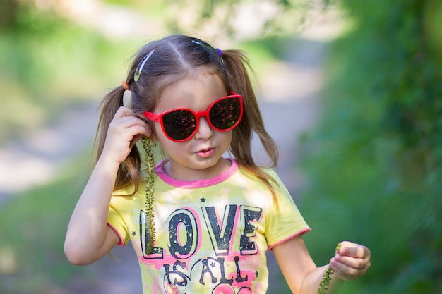 La niña se prueba unos pendientes de un árbol.