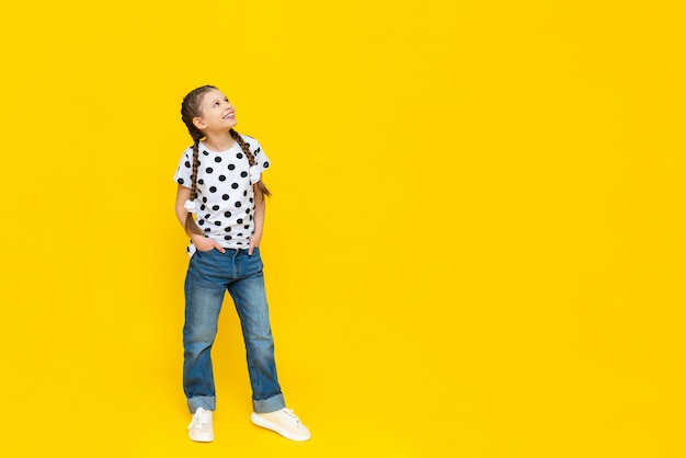 La niña puso sus manos en sus jeans y con una hermosa sonrisa miró hacia arriba.