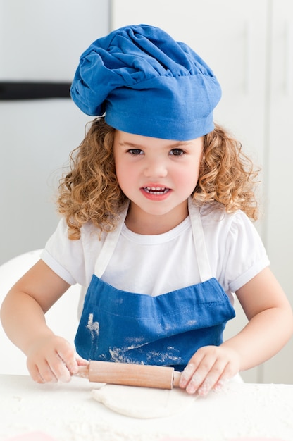 Niña que cuece en la cocina