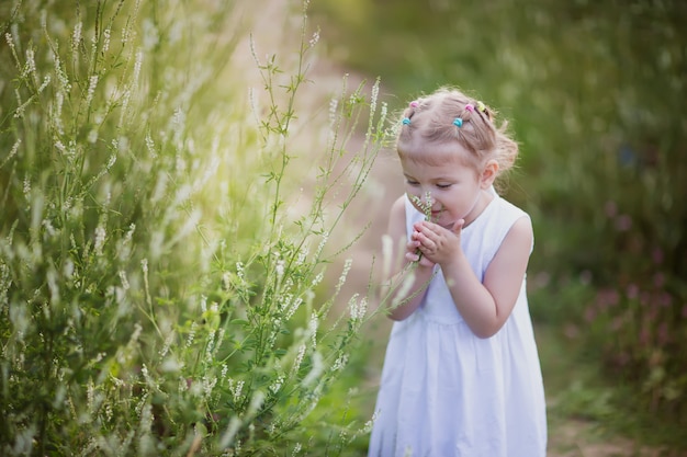 Niña que huele una flor