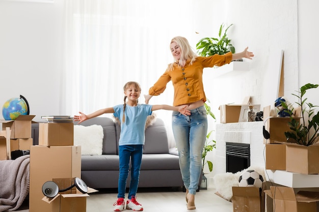 Niña que se muda a una casa nueva, cerca de una caja de cartón.